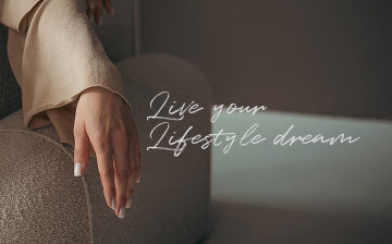 Live your Lifestyle dream — mulher de manga longa bege sentada em poltrona.