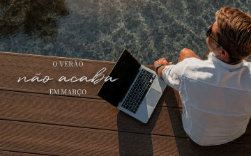 O verão não acaba em março — homem com notebook em deck de madeira ao lado da piscina.